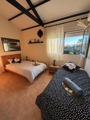 a bedroom with two beds and a window at Solea Alcayna in La Alcayna