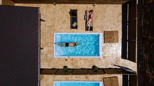 an overhead view of a pool with a person swimming at Kanva Suites in Korinós