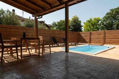 a patio with a table and chairs and a swimming pool at Kanva Suites in Korinós