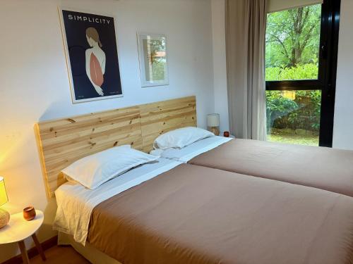 a bedroom with a large white bed with a window at AIzaetxea in Jaca
