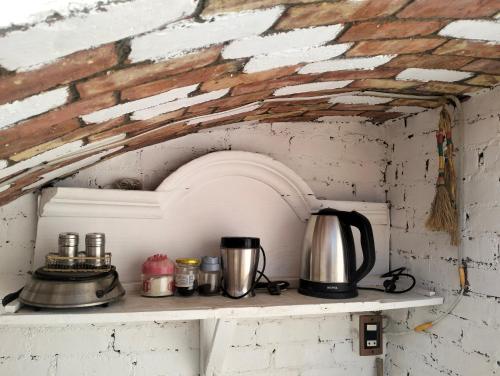 a counter with a coffee pot and a kettle at Roma House in Aswan