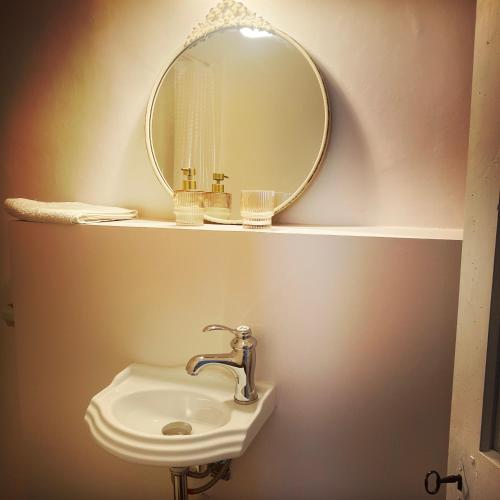 a bathroom with a sink and a mirror on a shelf at B&B Vigne Vierge in Aigne