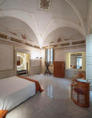 a large bedroom with a bed and a desk and a room at Palazzo Alchimia in Fasano