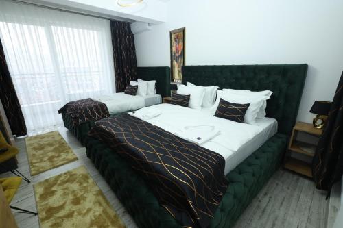 two beds in a bedroom with a green headboard at Golden Hill Palace in Novi Pazar