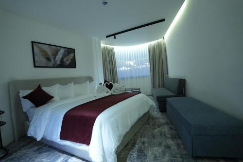 a bedroom with a large bed and a chair at Roya Downtown Boutique Hotel in Amman