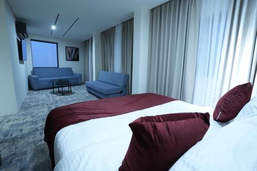 a hotel room with a bed and a couch at Roya Downtown Boutique Hotel in Amman