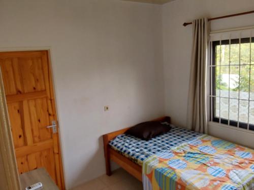 una camera da letto con un letto, una finestra e una porta di Latief appartement a Tamanredjo