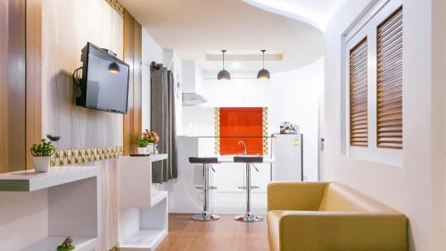 a kitchen with a sink and a tv in a room at Sunset Residence Pinklao in Bangkok