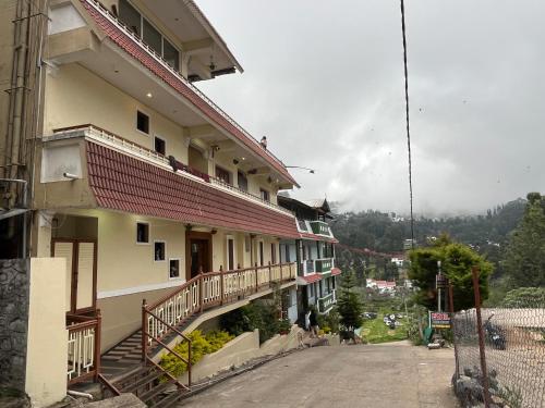 a building with a staircase next to a street at EZHIL Residency in Kodaikānāl