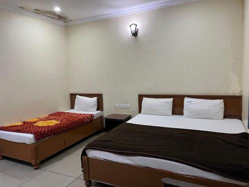 two beds in a room with two beds sidx sidx sidx sidx at EZHIL Residency in Kodaikānāl