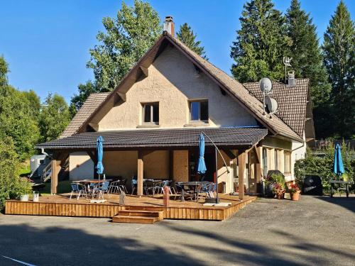 a house with a patio and tables and chairs at B&B Gite les Baudy in Le Haut-du-Them