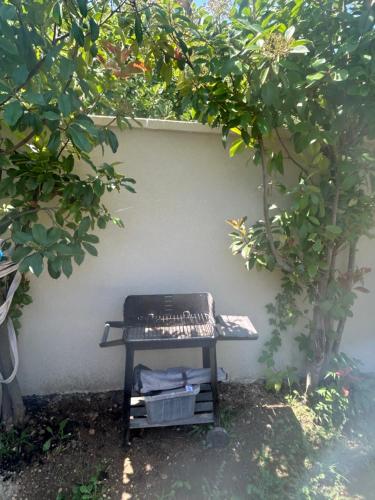 a grill sitting on a table next to a wall at Villa moderne adapté aux PMR in Carpentras