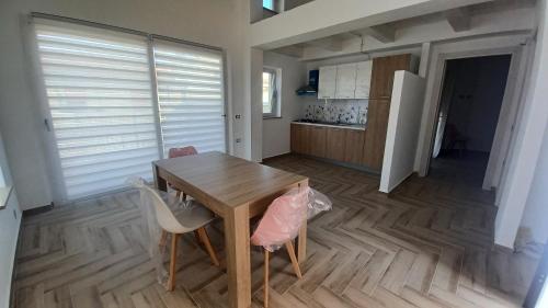 a kitchen with a wooden table and a dining room at La Perla DP in Ricadi