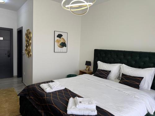 a bedroom with a large bed with towels on it at Golden Hill Palace in Novi Pazar