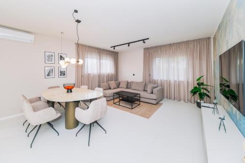 ein Wohnzimmer mit Tisch und Stühlen in der Unterkunft Luxury Suites Zaton by Belmont Realty in Zaton