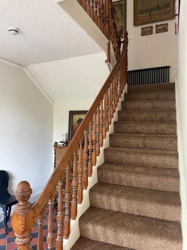 a staircase in a home with wooden railings at Traditional farm house in Antrim in Muckamore
