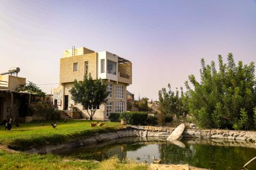 a house with a pond in front of a building at Farmhouse Loft Apartment at Mogador Essaouira 