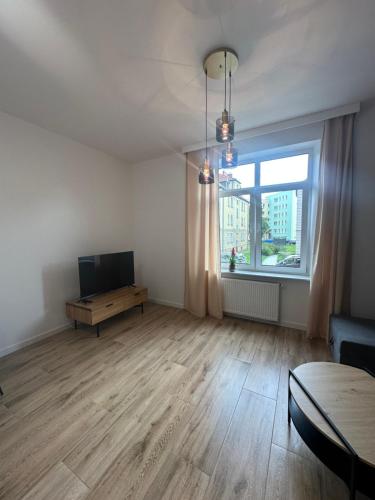 an empty living room with a television and a table at Apartament mieszkanie blisko centrum nowe zadbane in Słupsk