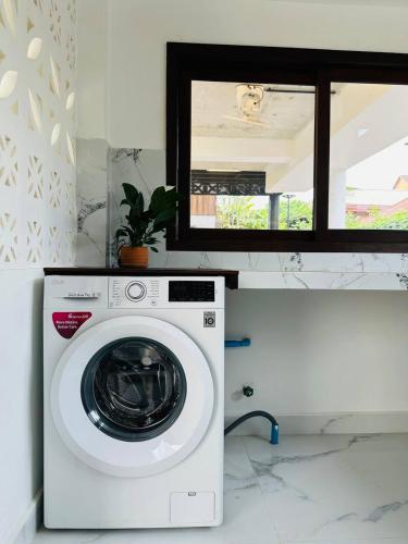 a washing machine in a kitchen with a mirror at Roya Khmer House in Siem Reap