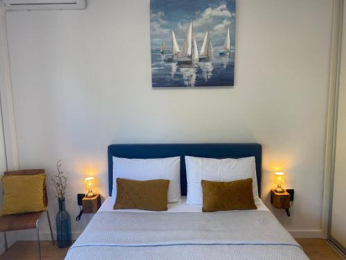 a bedroom with a bed with two lamps and a painting of sailboats at Dalmatia Nin apartment in Nin