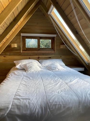 a large bed in a attic with a window at Hermoso chalet en marinilla in Marinilla