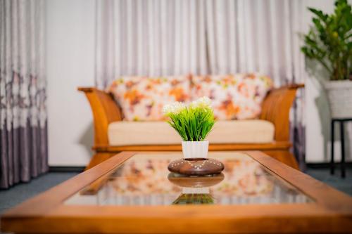 a living room with a coffee table with a plant on it at Royal Crest Villa in Batawala