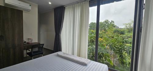 a bedroom with a bed and a large window at Coco Retreat in Tân Phú
