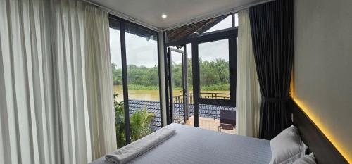 a bedroom with a bed and a view of a balcony at Coco Retreat in Tân Phú