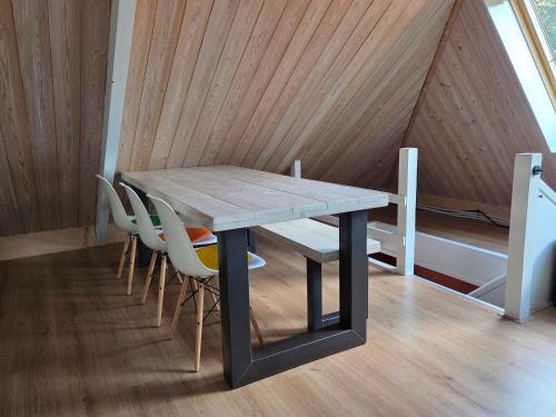 a table and chairs in a room with a wooden ceiling at Aan de Burgwal in Enkhuizen