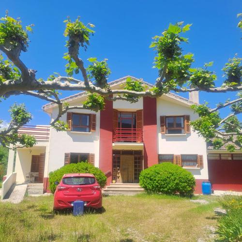 a red car parked in front of a house at Ezemil Etxea in Lumbier