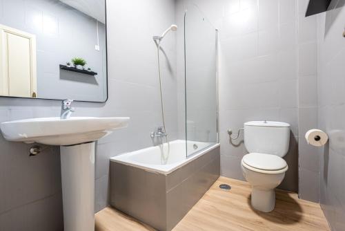 a white bathroom with a sink and a toilet at Casa de la Alegría Guest House in Granada