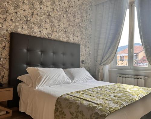 a bedroom with a large bed and a window at Hotel Ligure in Alassio