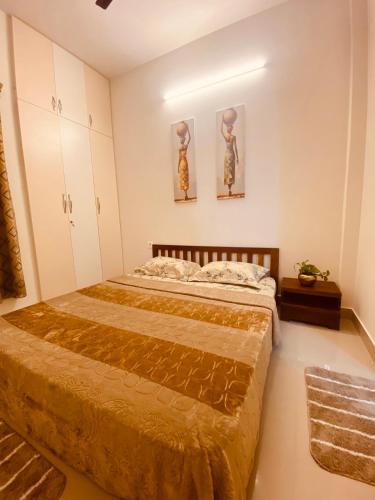 a bedroom with a bed and two pictures on the wall at MIRA VISTA - Cozy 2 BHK Condo - Chennai in Siruseri