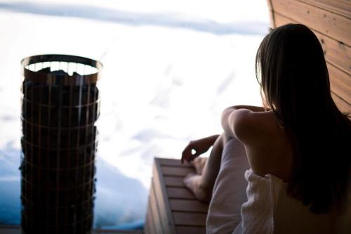 a woman sitting on a balcony looking out the window at Nada Brahma Retreats in Dailley