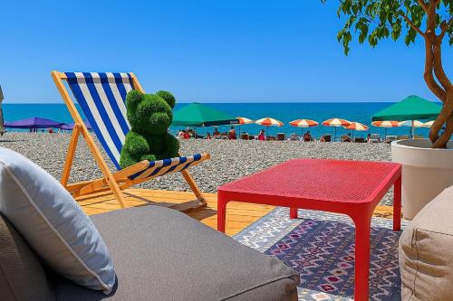 a teddy bear sitting in a chair on a beach at პანორამა კვარიათი in Kvariat'i