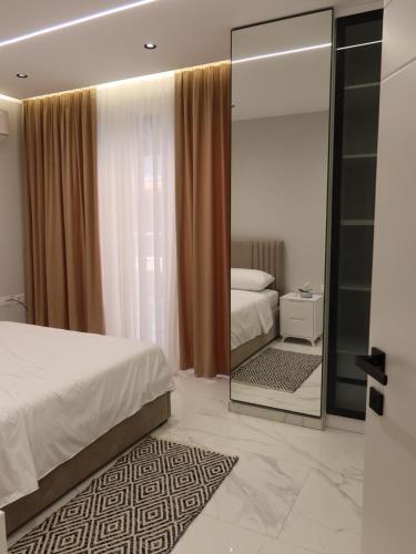 a bedroom with a bed and a large mirror at Marbel Apartments in Shëngjin