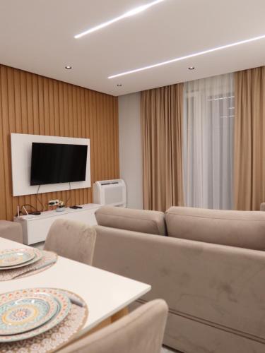 a hotel room with chairs and a flat screen tv at Marbel Apartments in Shëngjin