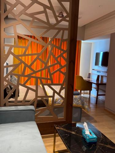 a living room with a wooden wall with a glass table at Galaxy blue sapphire plaza in Ghaziabad