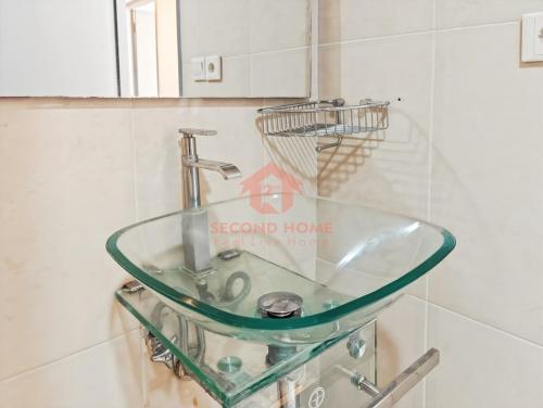 a glass sink in a bathroom with a mirror at Large & Strategic 3BR Taman Rasuna Apt Pool in Jakarta