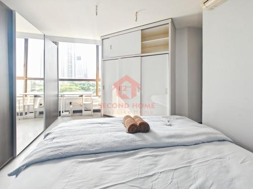 a bedroom with a bed with two slippers on it at Large & Strategic 3BR Taman Rasuna Apt Pool in Jakarta