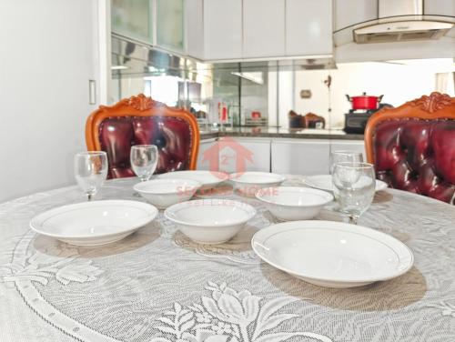 a table with plates and wine glasses on it at Large & Strategic 3BR Taman Rasuna Apt Pool in Jakarta