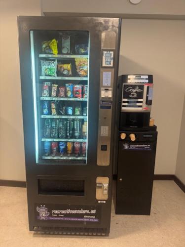 a vending machine with drinks in it next to a coffee at El Albuergo in Llanes