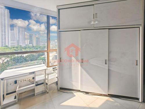 a room with a desk and a large window at Large & Strategic 3BR Taman Rasuna Apt Pool in Jakarta