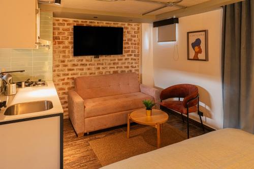 a living room with a couch and a tv on a brick wall at 5Q HOUSE Zona G in Bogotá