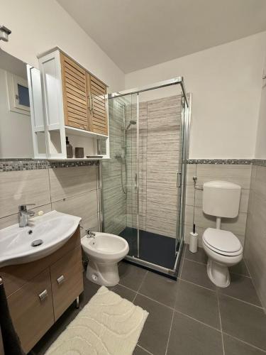 a bathroom with a toilet and a sink and a shower at Lago di Lugano - Casa Cecilia in Lavena Ponte Tresa