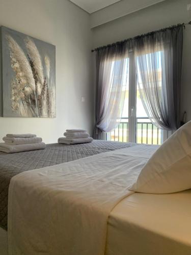 a bedroom with two beds and a large window at FK Apartment Sea View Balcony 60 m to the Beach Near Athens Airport and Rafina Port in Artemida