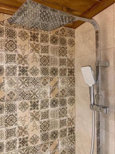 a shower in a bathroom with a tile wall at FK Apartment Sea View Balcony 60 m to the Beach Near Athens Airport and Rafina Port in Artemida
