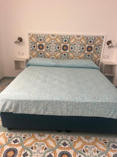 a bedroom with a bed with a blue comforter at Vincanto Maiori Costiera Amalfitana in Maiori