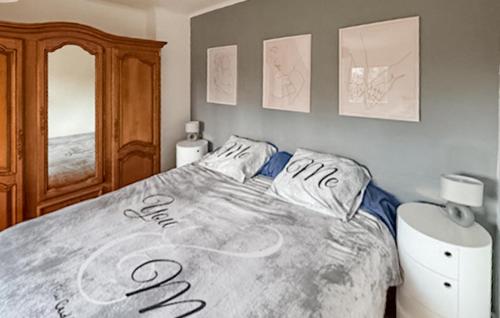 a bed with writing on it in a bedroom at 3 Bedroom Gorgeous Home In Plouaret in Plouaret