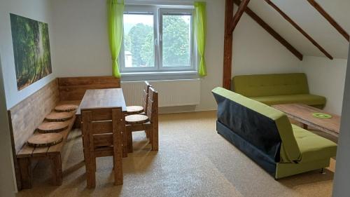 a living room with a table and a couch at Penzion Zelená zahrada in Kladenské Rovné